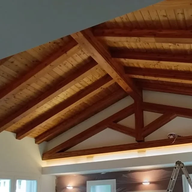 Soffitto in legno con travi scontornate da cartongesso e illuminazione integrata
